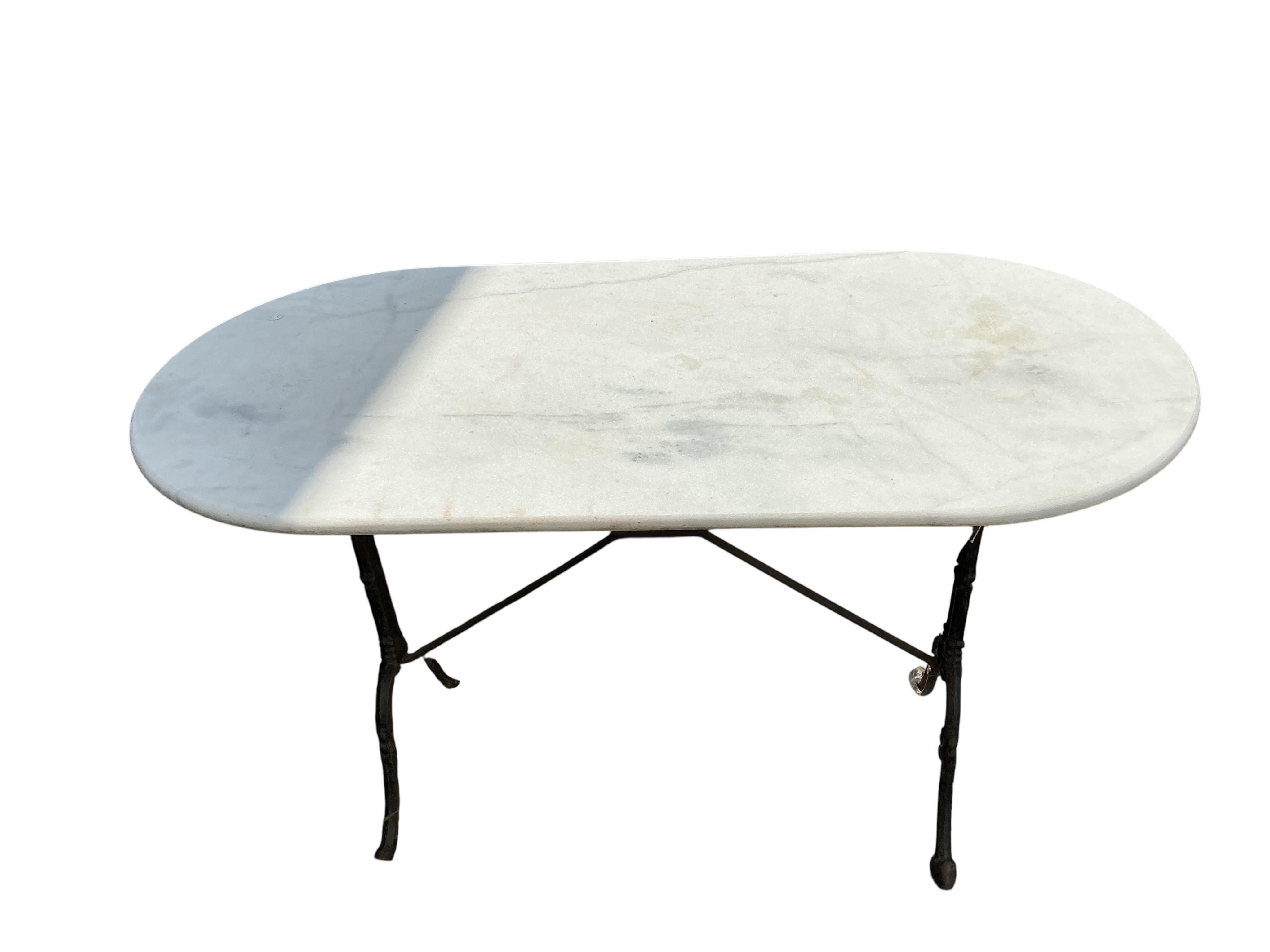 An oval reconstituted marble and cast iron garden table, width 120cm, depth 60cm, height 71cm
